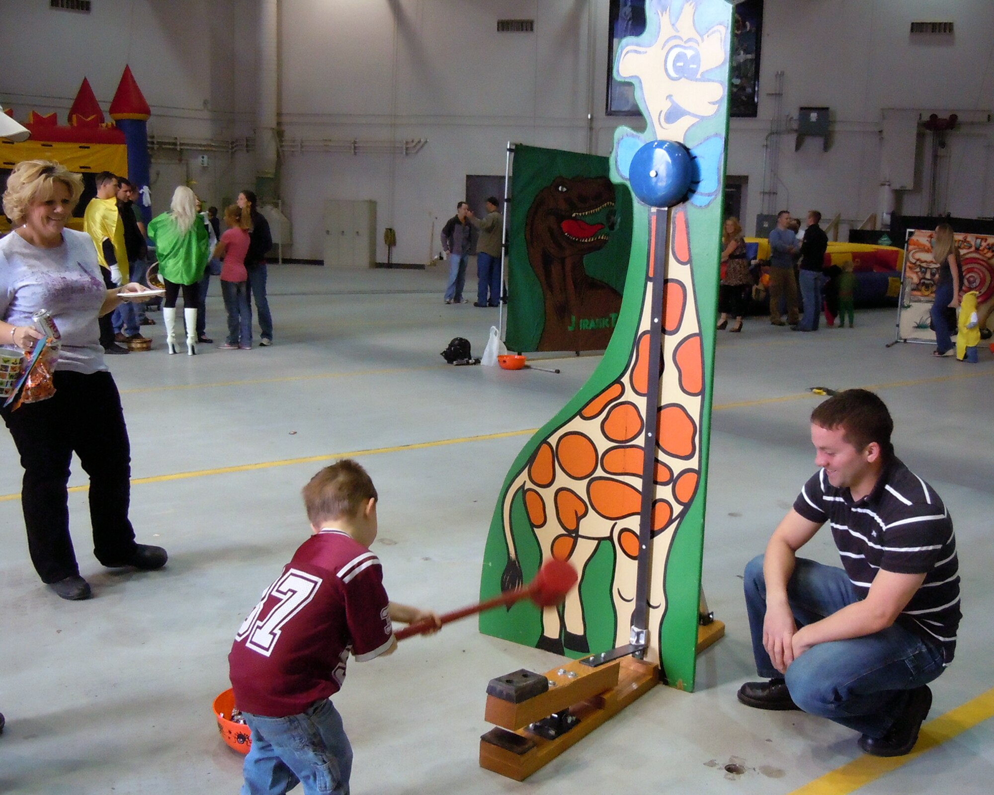 1st Lt. Vincent Horn, 12th Missile Squadron ICBM combat crew deputy commander, watches as Little Warrior Clayton, 4, tests his strength at the Operations Group Fall Festival Oct. 23 at the 3-bay Hangar. His mother Rose Borger, 341st Operations Support Squadron unit program coordinator, looks on. (courtesy photo)