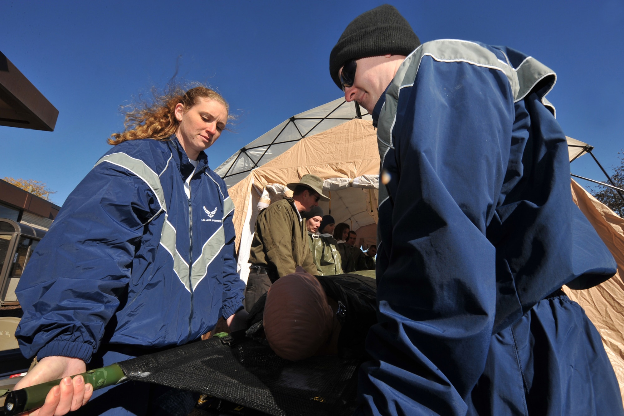 OFFUTT AIR FORCE BASE, Neb. -- (Left) Staff Sgt. Jamie Hill and (right) Senior Airman Michael Dummitt, both with the 55th Medical Group, lead a litter team during a decontamination exercise outside the Erhling Bergquist Clinic here Oct. 22. The training required 17 medics to process a litter-bound dummy and two ambulatory "patients" through four decontamination stations -- undress, wash, rinse and redress.  The litter-bound dummy started the decontamination process by going through a triage station as well to assess its injuries.

U.S. Air Force photo by Charles Haymond
[RELEASED] by Deborah Aragon