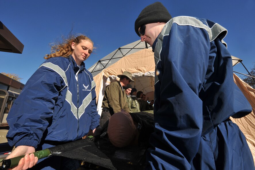 OFFUTT AIR FORCE BASE, Neb. -- (Left) Staff Sgt. Jamie Hill and (right) Senior Airman Michael Dummitt, both with the 55th Medical Group, lead a litter team during a decontamination exercise outside the Erhling Bergquist Clinic here Oct. 22. The training required 17 medics to process a litter-bound dummy and two ambulatory "patients" through four decontamination stations -- undress, wash, rinse and redress.  The litter-bound dummy started the decontamination process by going through a triage station as well to assess its injuries.

U.S. Air Force photo by Charles Haymond
[RELEASED] by Deborah Aragon
