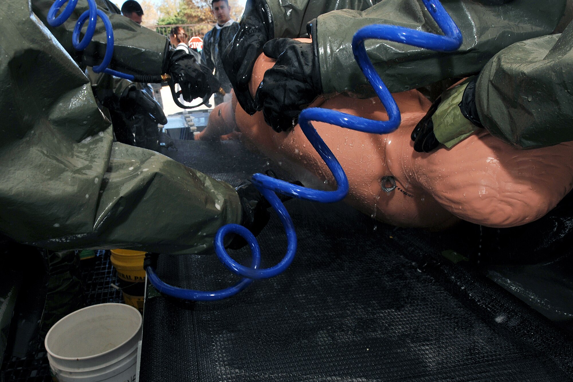 OFFUTT AIR FORCE BASE, Neb. -- Team members from the 55th Medical Group wash a simulated contaminated person during a decontamination exercise outside the Erhling Bergquist Clinic here Oct. 22. The training required 17 medics to process a litter-bound dummy and two ambulatory "patients" through four decontamination stations -- undress, wash, rinse and redress.  The litter-bound dummy started the decontamination process by going through a triage station as well to assess its injuries.

U.S. Air Force photo by Charles Haymond
[RELEASED] by Deborah Aragon