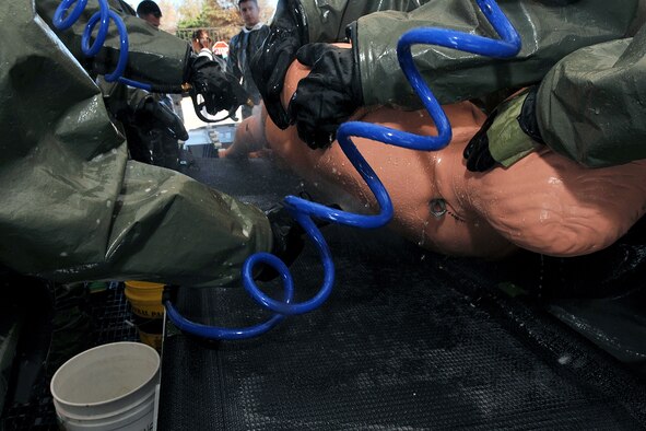 OFFUTT AIR FORCE BASE, Neb. -- Team members from the 55th Medical Group wash a simulated contaminated person during a decontamination exercise outside the Erhling Bergquist Clinic here Oct. 22. The training required 17 medics to process a litter-bound dummy and two ambulatory "patients" through four decontamination stations -- undress, wash, rinse and redress.  The litter-bound dummy started the decontamination process by going through a triage station as well to assess its injuries.

U.S. Air Force photo by Charles Haymond
[RELEASED] by Deborah Aragon