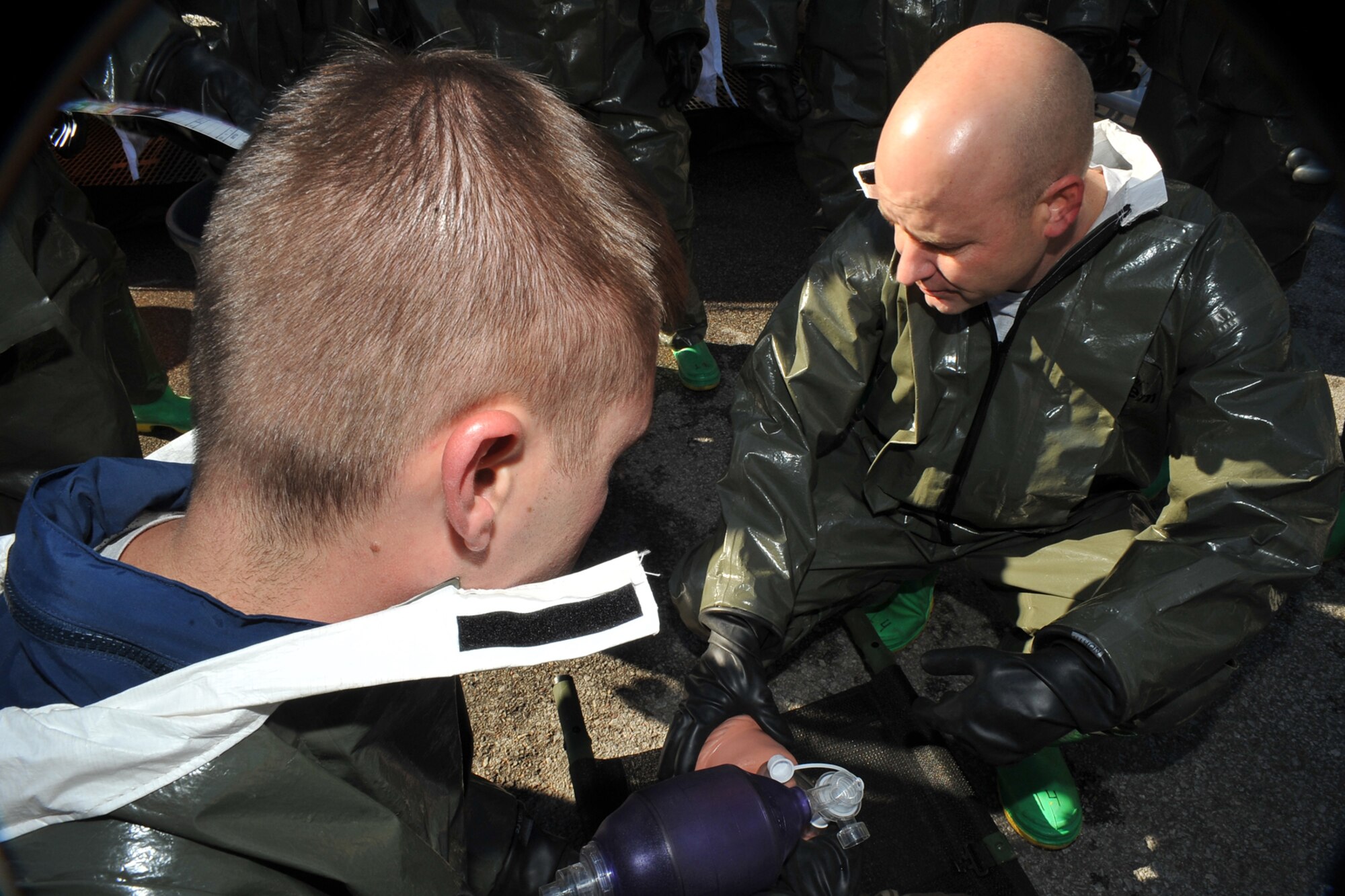 OFFUTT AIR FORCE BASE, Neb. -- (From left) Technical Sgt. Eric Nelson and 1st Lt. Jeffrey Herchler, both with the 55th Medical Group, perform self aid buddy care during a decontamination exercise outside the Erhling Bergquist Clinic here Oct. 22. The training required 17 medics to process a litter-bound dummy and two ambulatory "patients" through four decontamination stations -- undress, wash, rinse and redress.  The litter-bound dummy started the decontamination process by going through a triage station as well to assess its injuries.

U.S. Air Force photo by Charles Haymond