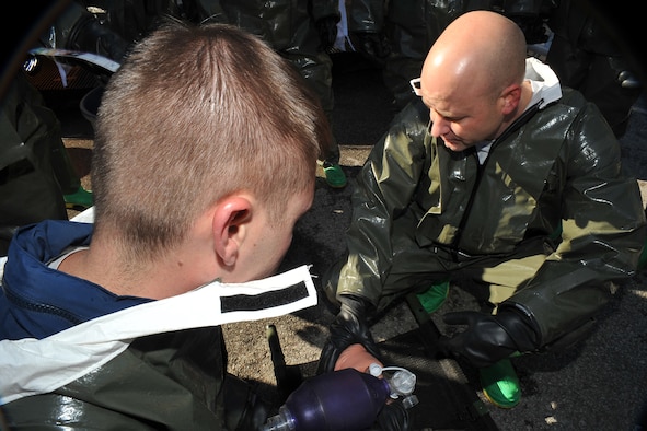 OFFUTT AIR FORCE BASE, Neb. -- (From left) Tech. Sgt. Eric Nelson and 1st Lt. Jeffrey Herchler, both with the 55th Medical Group, perform self aid buddy care during a decontamination exercise outside the Erhling Bergquist Clinic here Oct. 22. The training required 17 medics to process a litter-bound dummy and two ambulatory "patients" through four decontamination stations -- undress, wash, rinse and redress. The litter-bound dummy started the decontamination process by going through a triage station as well to assess its injuries. U.S. Air Force photo by Charles Haymond 

 
R
e
m
o
 