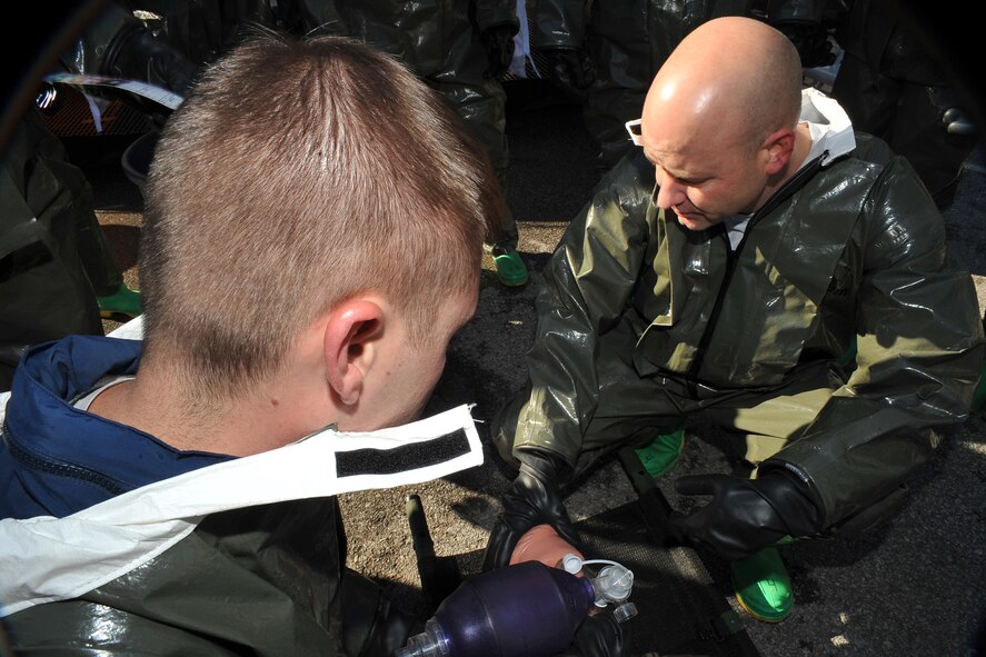 OFFUTT AIR FORCE BASE, Neb. -- (From left) Technical Sgt. Eric Nelson and 1st Lt. Jeffrey Herchler, both with the 55th Medical Group, perform self aid buddy care during a decontamination exercise outside the Erhling Bergquist Clinic here Oct. 22. The training required 17 medics to process a litter-bound dummy and two ambulatory "patients" through four decontamination stations -- undress, wash, rinse and redress.  The litter-bound dummy started the decontamination process by going through a triage station as well to assess its injuries.

U.S. Air Force photo by Charles Haymond
