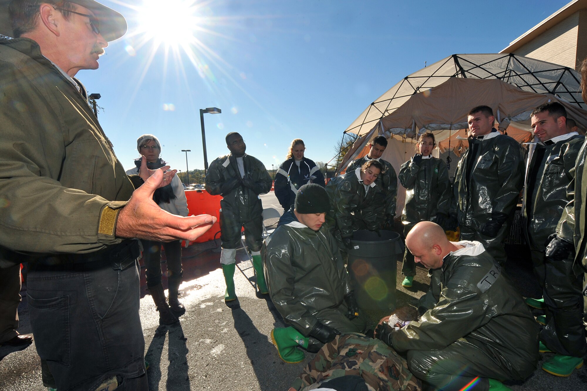 OFFUTT AIR FORCE BASE, Neb. -- (Left) Tom Bocek, a contractor with DECON, LLC., teaches team members from the 55th Medical Group proper self aid buddy care procedures during a decontamination exercise outside the Erhling Bergquist Clinic here Oct. 22. The training required 17 medics to process a litter-bound dummy and two ambulatory "patients" through four decontamination stations -- undress, wash, rinse and redress.  The litter-bound dummy started the decontamination process by going through a triage station as well to assess its injuries.

U.S. Air Force photo by Charles Haymond
[RELEASED] by Deborah Aragon