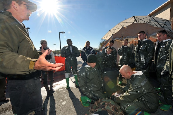 OFFUTT AIR FORCE BASE, Neb. -- (Left) Tom Bocek, a contractor with DECON, LLC., teaches team members from the 55th Medical Group proper self aid buddy care procedures during a decontamination exercise outside the Erhling Bergquist Clinic here Oct. 22. The training required 17 medics to process a litter-bound dummy and two ambulatory "patients" through four decontamination stations -- undress, wash, rinse and redress.  The litter-bound dummy started the decontamination process by going through a triage station as well to assess its injuries.

U.S. Air Force photo by Charles Haymond
[RELEASED] by Deborah Aragon