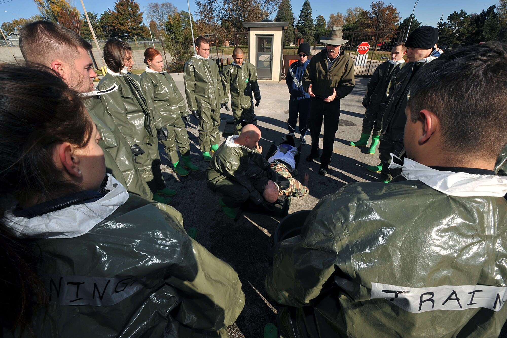 OFFUTT AIR FORCE BASE, Neb. -- (Center) Tom Bocek, a contractor with DECON, LLC., teaches team members from the 55th Medical Group the proper self aid buddy care procedures during a decontamination exercise outside the Erhling Bergquist Clinic here Oct. 22. The training required 17 medics to process a litter-bound dummy and two ambulatory "patients" through four decontamination stations -- undress, wash, rinse and redress.  The litter-bound dummy started the decontamination process by going through a triage station as well to assess its injuries.

U.S. Air Force photo by Charles Haymond
[RELEASED] by Deborah Aragon