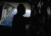 A load master in the Italian Air Force opens the rear hatch of a C-27J Spartan while flying over New England on Oct. 22, 2010. The Load Master opens the hatch during a familiarization tour for the Connecticut Guardsmen. (U.S. Air Force photo by Airman 1st Class Emmanuel Santiago/Released)