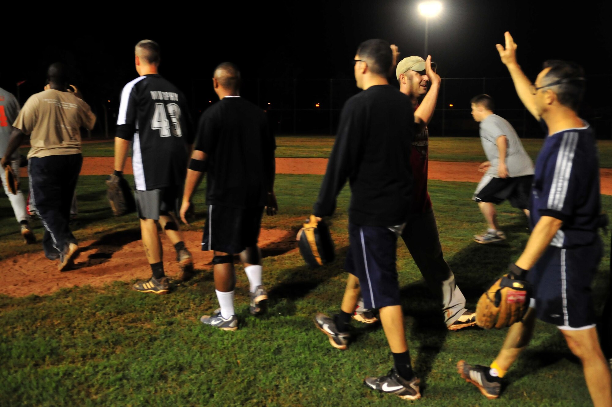 The Office Jockeys and the No Names congratulate each other at the mound after a game during the Late Night Softball Tournament Oct. 22, 2010 at Incirlik Air Base, Turkey.  The Office Jockeys defeated the No Names 8-0.  (U.S. Air Force photo by Senior Airman Ashley Wood/Released)