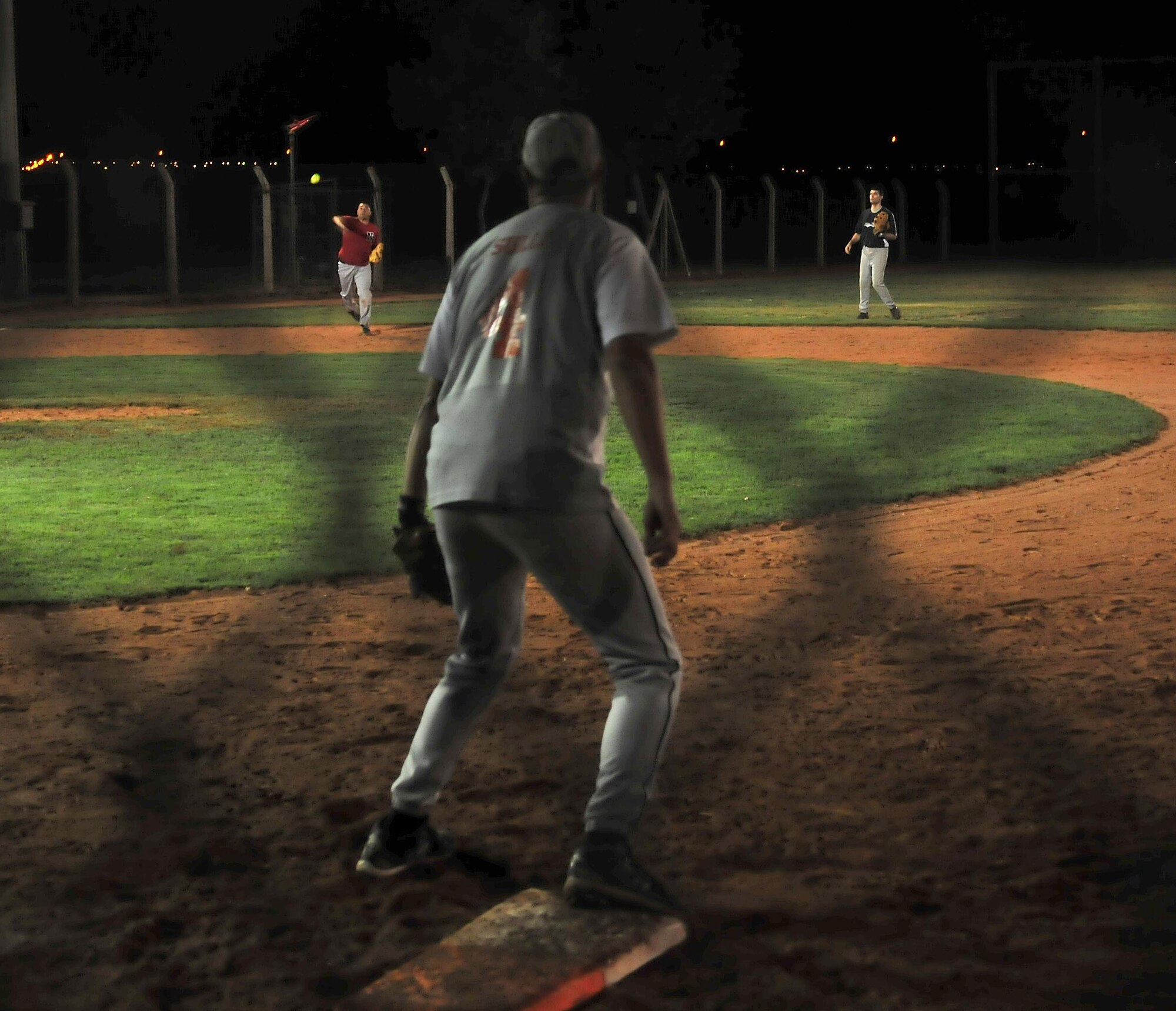 Anthony Hyatt, Office Jockeys team member assigned to the 39th Air Base Wing, throws the ball to his teammate Randy Sullivan, also assigned to the 39th Air Base Wing, during the Late Night Softball Tournament Oct. 22, 2010 at Incirlik Air Base, Turkey.  The Office Jockeys beat the No Names 8-0 moving them into the championship game.  (U.S. Air Force photo by Senior Airman Ashley Wood/Released)