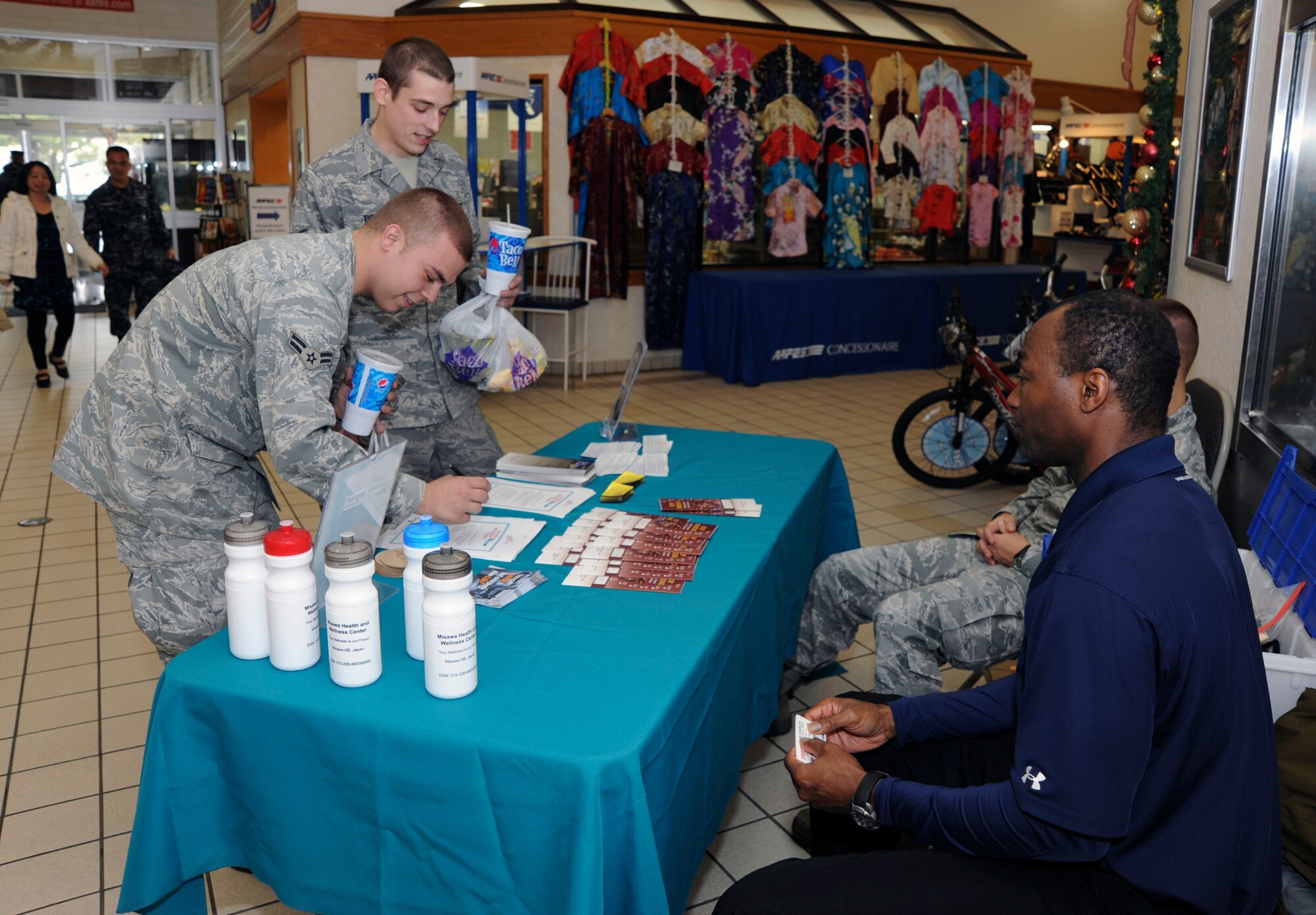 U.S. Air Force Airman 1st Class Daryn Connors, left, 35th Maintenance Squadron and Airman 1st Class Michael Theroux, back, 35th MXS, visit the Smoking Cessation table at Misawa Air Base, Japan, Nov. 1, 2010. The Airman signed contracts to quit smoking for 24-hour period. Orlando Nurse, Health and Wellness Center, right, educated visitors on the dangers of tobacco use in observance of Smoking awareness month in November. (U.S. Air Force photo by Tech. Sgt. Russell McBride/Released)