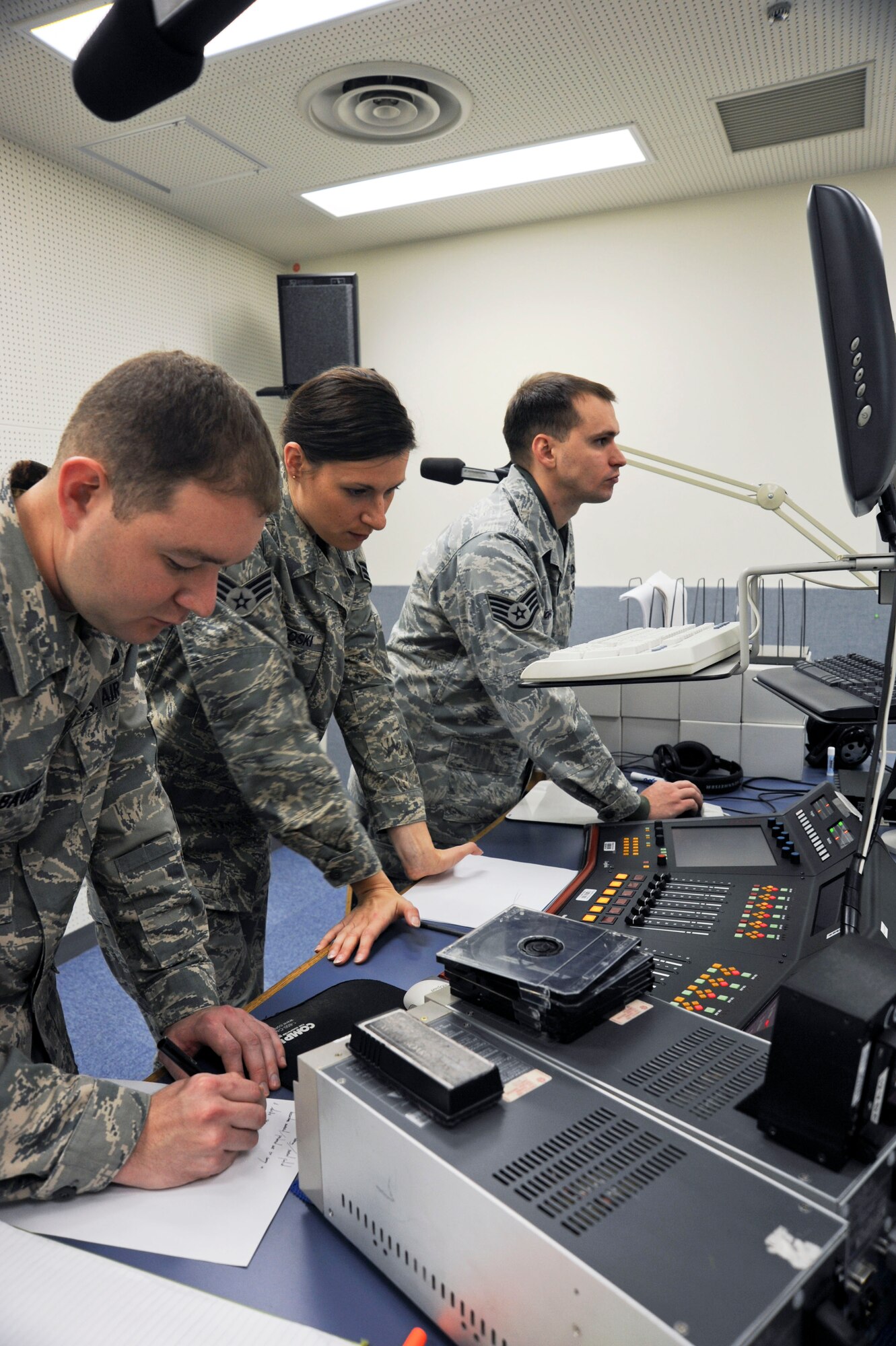 U.S Air Force Airman James Bauer, left, Senior Airman Jessica Lockoski, center, and Staff Sgt. Chad Strohmeyer, right, all with 35th Fighter Wing Public Affairs, review and prioritize questions for the 35 FW Commander during Commander's Open Line radio show at Misawa Air Base, Japan, Oct. 29, 2010. Questions from base community members are received by phone, email and through Facebook. (U.S. Air Force photo by Tech. Sgt. Russell McBride/ Released)
