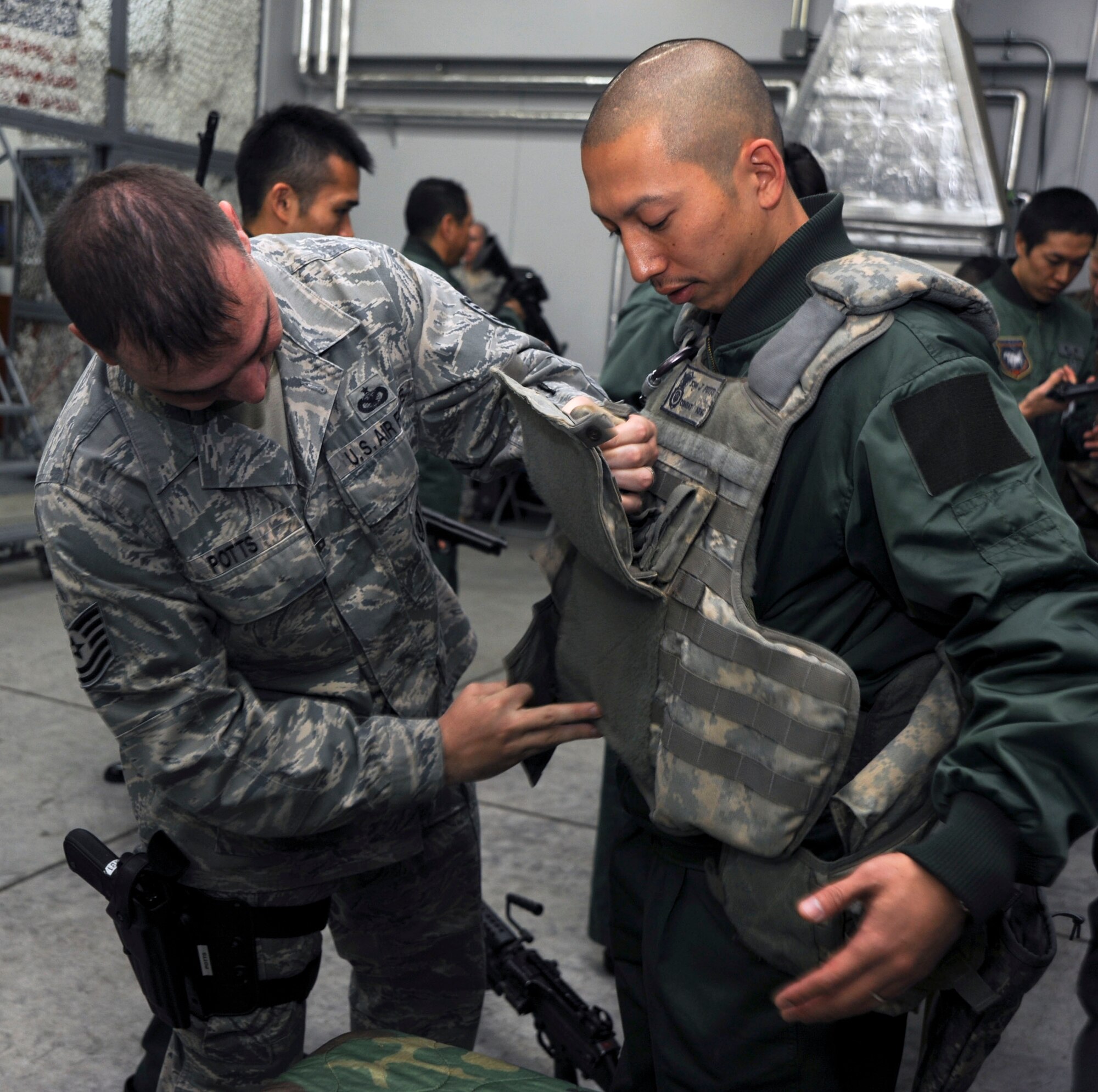 U.S. Air Force Tech. Sgt. Jeremy Potts, left, 35th Security Forces Squadron, assists Chitose Japan Air Self-Defense Force Staff Sgt. Tomonori Miura, adjusting body armor at Misawa Air Base, Japan, Oct. 27, 2010.  The security forces displayed different weapons and gear, which gave the JASDF visitors an opportunity to learn more about U.S operations. (U.S. Air Force photo by Tech. Sgt. Russell McBride/Released)