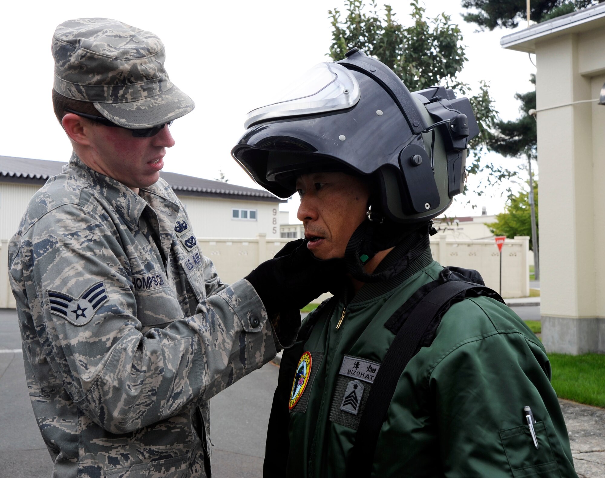 U.S. Air Force Senior Airman Matthew Thompson, left, 35th Civil Engineer Squadron Explosive Ordnance Division, helps Chief Master Sgt. Tetsuya Mizohata, Chitose Japan Air Self-Defense Force, don EOD gear at Misawa Air Base, Japan, Oct. 27, 2010. The JASDF members visited as a part of a bi-lateral sponsor-training week. (U.S. Air Force photo by Tech. Sgt. Russell McBride/Released)