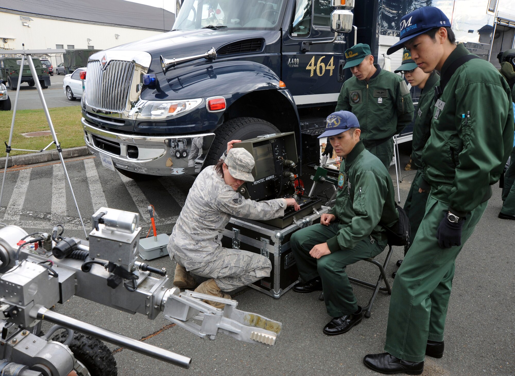 U.S. Air Force Senior Airman Danee Hicks, left, 35th Civil Engineer Squadron Explosive Ordnance Division, shows members of Chitose Japan Air Self-Defense Force how to operate an EOD robot at Misawa Air Base, Japan, Oct. 27, 2010. The robot is used in place of humans to prevent the loss of life when retrieving improvised explosive devices.  (U.S. Air Force photo by Tech. Sgt. Russell McBride/Released)