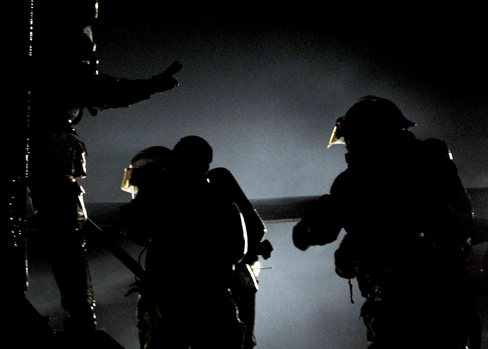 SOUTHWEST ASIA -- Firefighters from the 386th Expeditionary Civil Engineering Squadron signal to each other during live-fire training here Oct. 27. Using a Mobile Aircraft Firefighter Trainer, 27 firefighters from the squadron extinguished exterior and interior fires, and performed rescue operations with 185-pound manikins. Live-fire training is an annual requirement for all USAF firefighters. (U.S. Air Force photo by Senior Airman Laura Turner)