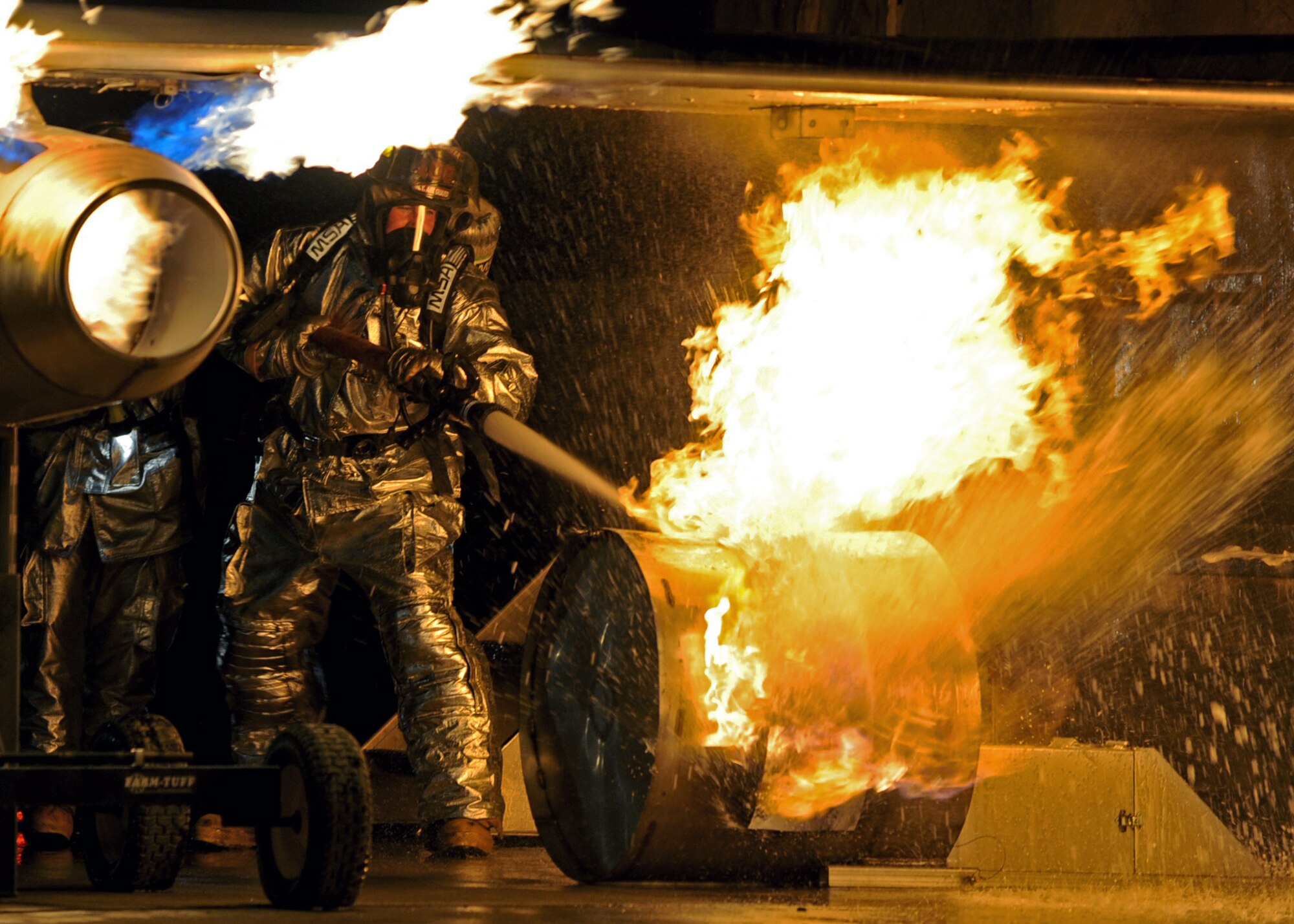 SOUTHWEST ASIA -- Firefighters from the 386th Expeditionary Civil Engineer Squadron practice extinguishing an aircraft fire at a U.S. military installation here Oct. 27. A Mobile Aircraft Firefighter Trainer was used to simulate a C-130 Hercules during the two-day live-fire training. Teams practiced by extinguishing interior and exterior fires, as well as by extracting manikins during rescue operations. (U.S. Air Force photo by Senior Airman Laura Turner)