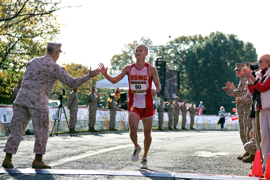 U.S. Marine Corps 1st Lt. Sean Barrett crosses the finish line of the 35th annual Marine Corps Marathon and claps hands with Marine Corps Gen. James F. Amos, commandant of the Marine Corps, in Arlington, Va., Oct. 31, 2010. Barrett finished the race in 2:24:08 and was the first Marine runner to cross the finish line.