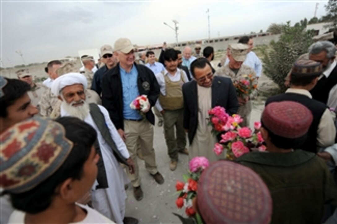 Deputy Secretary of Defense William J. Lynn III and Governor Ghulab Mangal receive flowers while visiting a newly constructed school in Nawa, Afghanistan, on Oct. 28, 2010.  