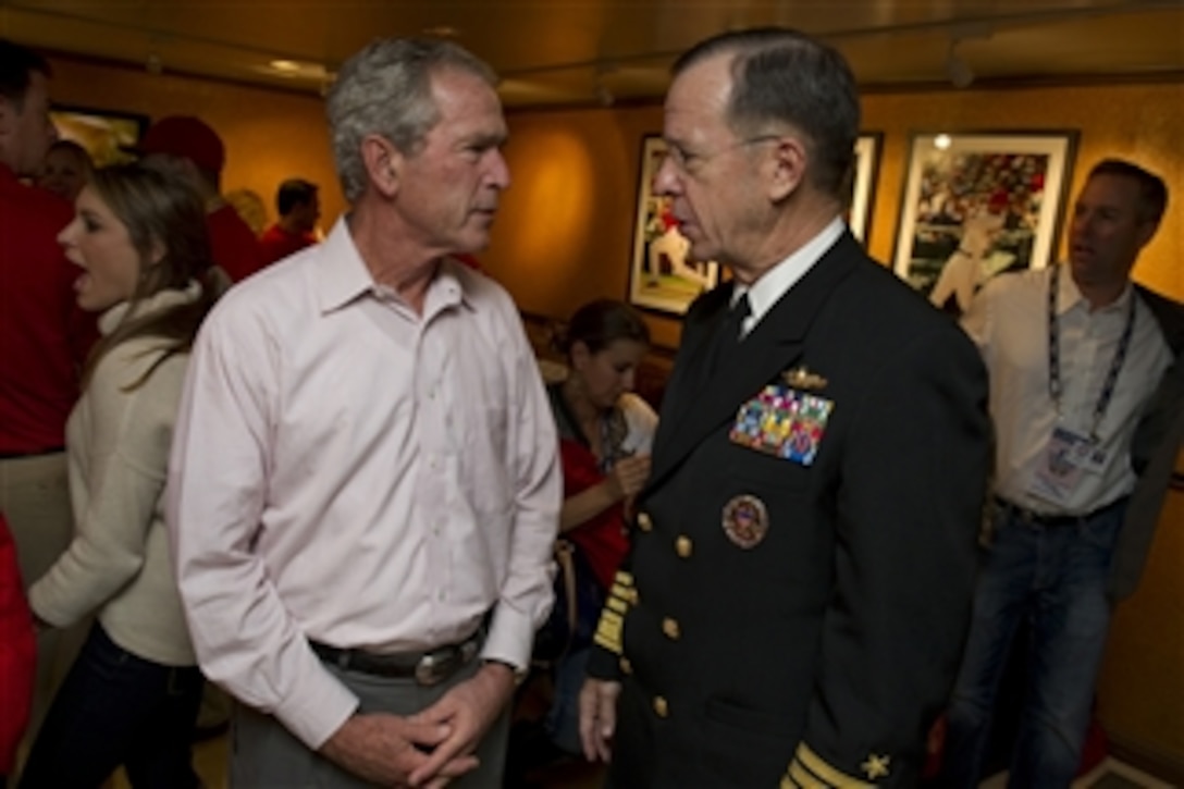 Chairman of the Joint Chiefs of Staff Adm. Mike Mullen speaks with President George W. Bush at Game 4 of the 106th World Series between the San Francisco Giants and Texas Rangers in Arlington, Texas, on Oct. 31, 2010.  Major League Baseball dedicated the game to the Welcome Back Veterans initiative that honors and encourages support of returning military members and their families.  