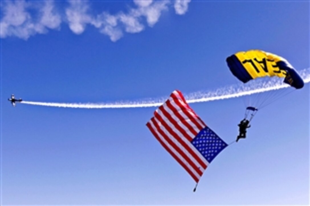 U.S. Navy Petty Officer 1st Class Thomas Kinn, assigned to the U.S. Navy parachute demonstration team, the Leap Frogs, parachutes with the American flag during the opening ceremony of the Cocoa Beach Air Show, Fla., Oct. 30, 2010. The air show is the cornerstone event for Air Force Week.