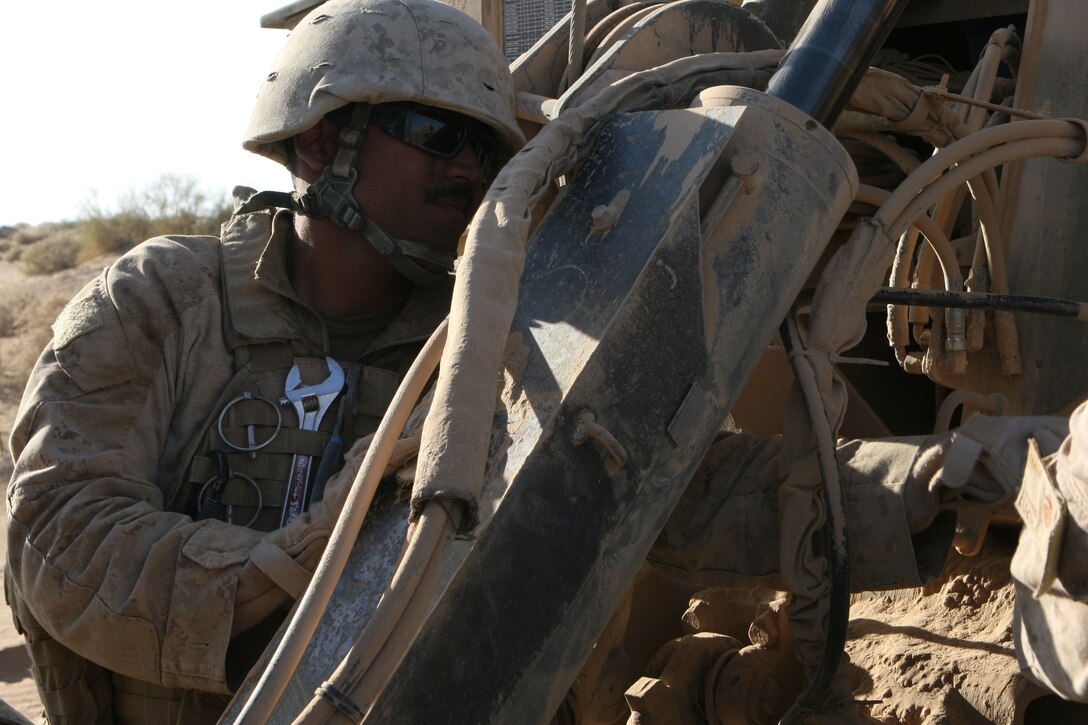 Sgt. Alex Cabreal, wrecker operator attached to Motor Transport Company B, Combat Logistics Battalion 3, 1st Marine Logistics Group (Forward), checks the connections between his wrecker and a fuel truck he was about to tow across the Helmand River in southern Afghanistan, Nov. 1. This is Cabreal’s second deployment as a wrecker operator.