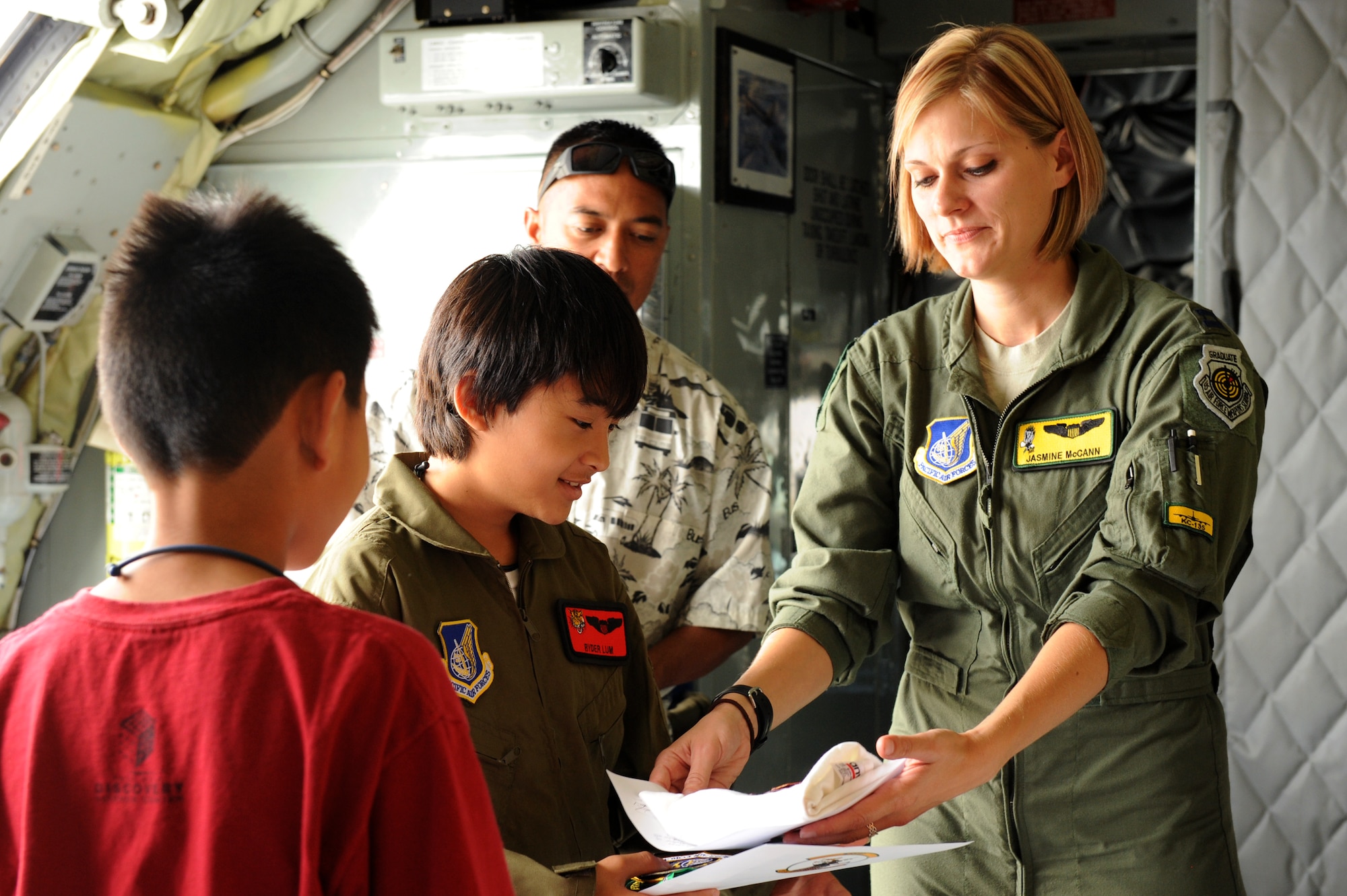Capt. Jasmine McCann, a 96th Air Refueling Squadron KC-135 pilot, gives 11-year-old Ryder Lum and his best friend Everett Fan momentos from their tour of the Hawaii Air National Guard KC-135 Stratotanker during his visit to Joint Base Pearl Harbor-Hickam Oct. 29, 2010. Ryder was part of the 535th Airlift Squadron’s quarterly Pilot for a Day program, which allows children with catastrophic disorders or illnesses to experience a day in the life of an Air Force pilot. Ryder was diagnosed with a cancerous brain tumor four years ago and has been in remission for almost two years. (U.S. Air Force photo/Staff Sgt. Carolyn Viss)