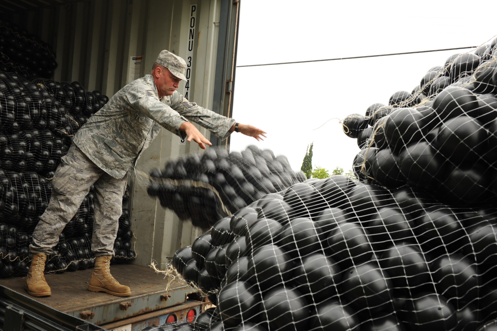 JOINT BASE PEARL HARBOR-HICKAM, Hawaii - Master Sgt. Daniel Williams, 15th Wing flight safety superintendent, helps load 70,000 "Armor Ball's" onto a truck from the back of a semi truck here, Oct. 26. The Bird Hazard Working Group initiated the bird hazard abatement as part of the Bird/Wildlife Aircraft Strike Hazard, also know as the BASH program, when members of 647th Services Squadron, 647th Contracting Squadron, 15th Wing safety office and Mamala Bay Golf Course workers released “Armor Balls” into the reservoir. (U.S. Air Force photo/Senior Airman Gustavo Gonzalez)
 
