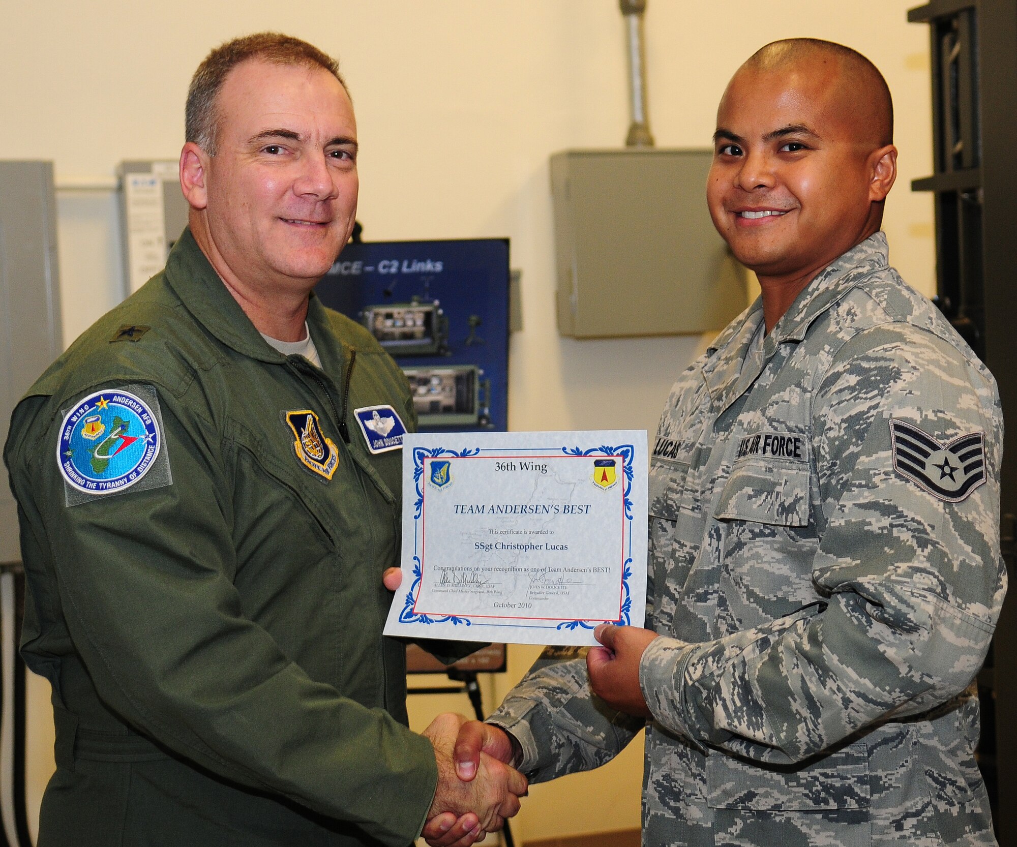 Brig. Gen. John Doucette, 36th Wing commander, presents Staff Sgt. Christopher Lucas, Detachment 3 knowledge operations management, with the Andersen's Best award, at Andersen Air Force Base, Guam, Oct. 22.Sergeant Lucas is an essential part of the Launch and Recovery Element providing its connection to the world through 36th Communications Squadron networks. Andersen's Best is a recognition program which highlights a top performer from the 36th Wing. Each week, supervisors nominate a member of their team for outstanding performance and the wing commander presents the selected Airman with an award. (U.S. Air Force photo/ Senior Airman Nichelle Anderson)