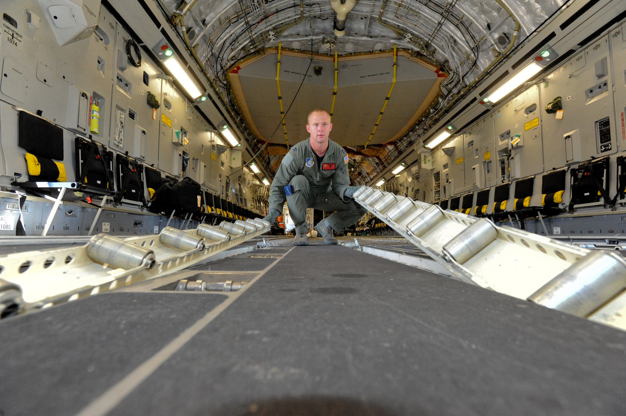 Capt. Mark Fischer, 535th Airlift Squadron pilot from Joint Base Pearl Harbor Hickam, converts the floor of a C-17 to its rolling side Oct. 14 at Fort Benning, Ga. A C-17 Globemaster III from the 15th Wing made the long journey from Hawaii to Fort Benning to support the student jump requirements of the 507th Airborne School. (U.S. Air Force photo/Staff Sgt. Nathan Allen)
