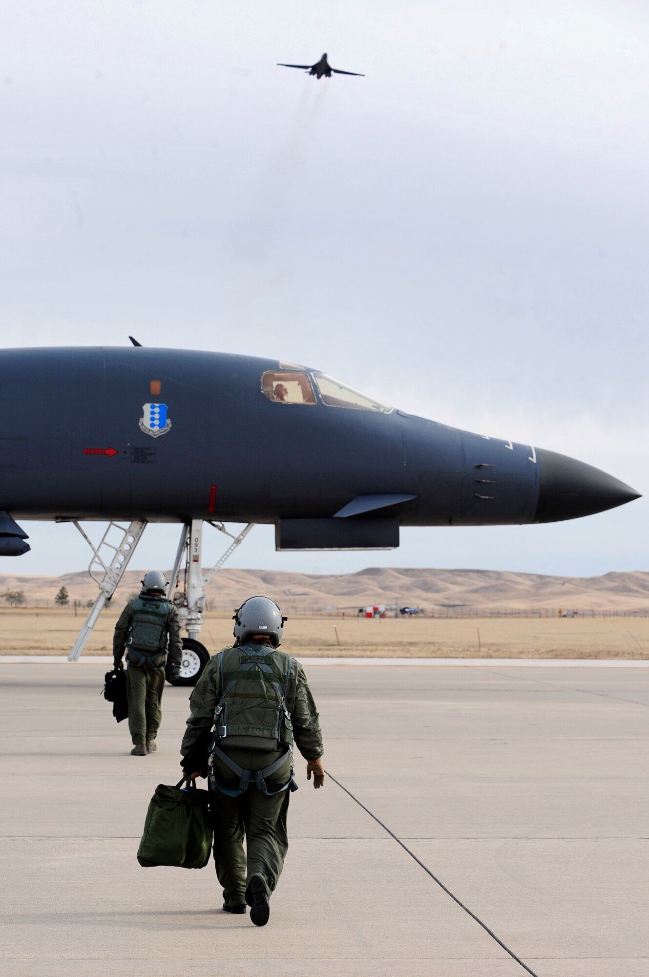 ELLSWORTH AIR FORCE BASE, S.D. - (Right) Capt. Tara Hart and Capt. Robb Fiechtner prepare to board a B-1B Lancer during an engine-running crew change, Oct. 27.  Capt. Hart and Fiechtner are both assigned to the 37th Bomb Squadron.  Airmen of the 28th Bomb Wing are preparing for a joint-service exercise at Barksdale Air Force Base, Ala., Nov. 5 through 14. (U.S. Air Force photo/Staff Sgt. Marc I. Lane)