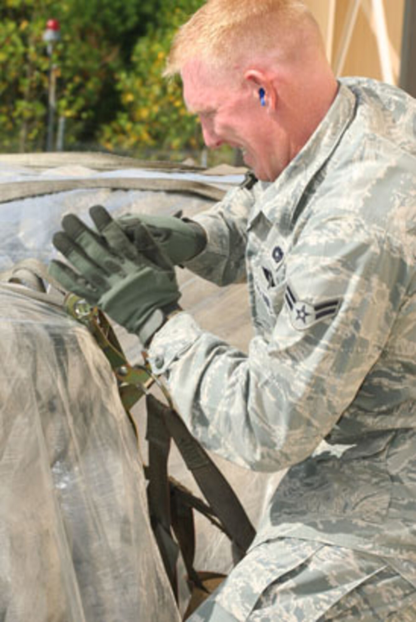 AIC Chris Meyer with the 39th Aerial Port Squadron, Peterson Air Force Base, Co., secures the cargo on the pallet he and his team built while competing in the pallet build up event at AFRC Port Dawg Challenge 2010 held here 25-29 Oct. (U.S. Air Force Photo/Don Peek)
