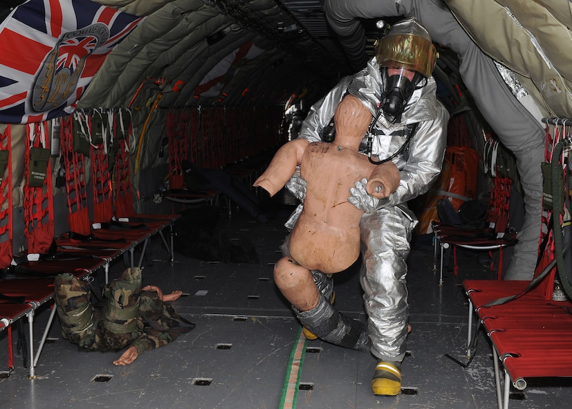 RAF MILDENHALL, England - A 100th Civil Engineer Squadron firefighter carries a dummy to safety during the Major Accident Response Exercise here, Nov. 2, 2010.  This MARE was used to prepare RAF Mildenhall firefighters for real-world aircraft mishaps.  (U.S. Air Force photos/Senior Airman Tabitha M. Lee)