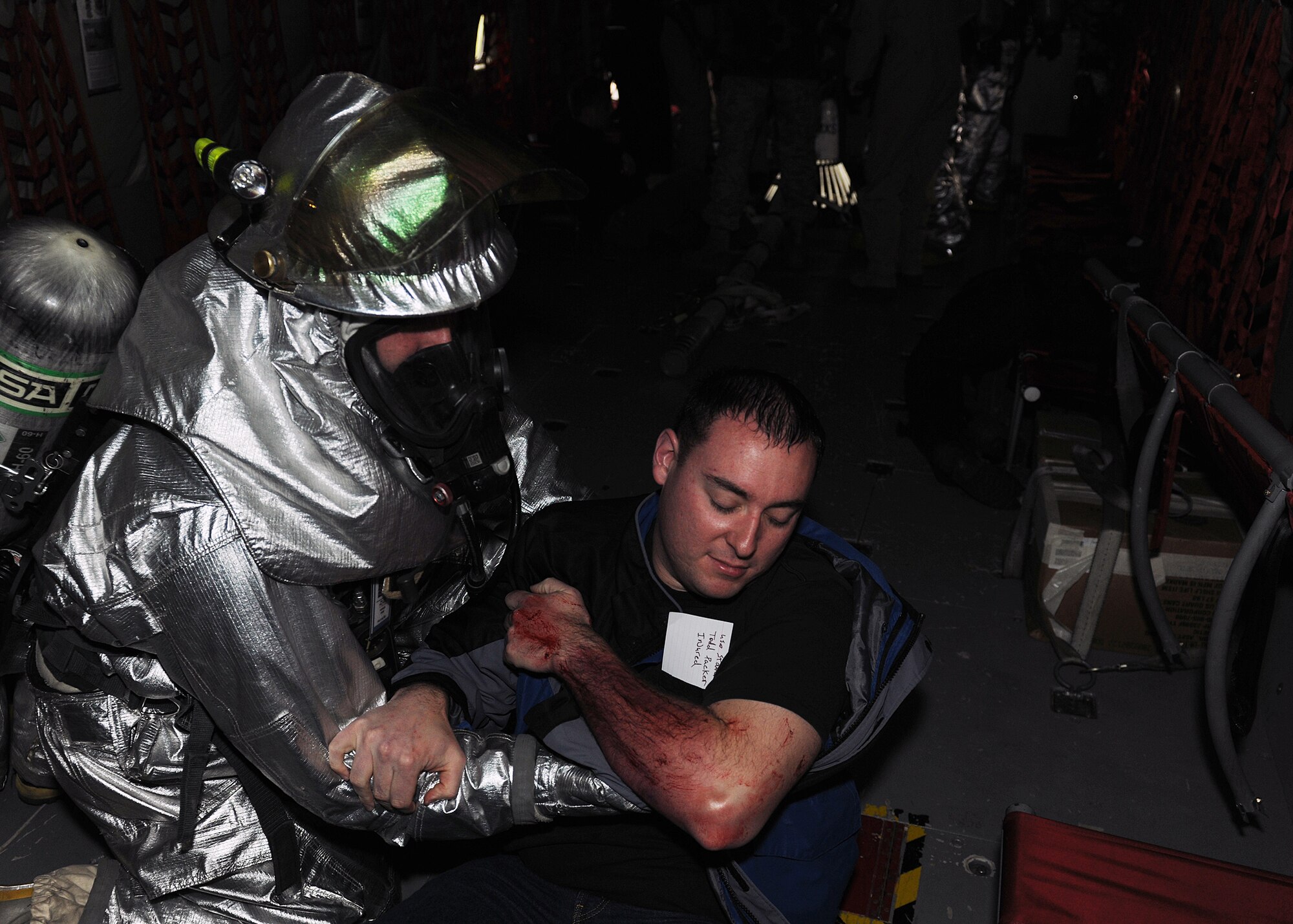 RAF MILDENHALL, England - A 100th Civil Engineer Squadron firefighter assists volunteer casualty, Senior Airman Cedar McQuigg, 100th Communication Squadron installation spectrum manager, during the Major Accident Response Exercise here, Nov. 2, 2010.  Volunteers dressed up as injured people to give the training a more realistic experience for the emergency response personnel.  (U.S. Air Force photos/Senior Airman Tabitha M. Lee)