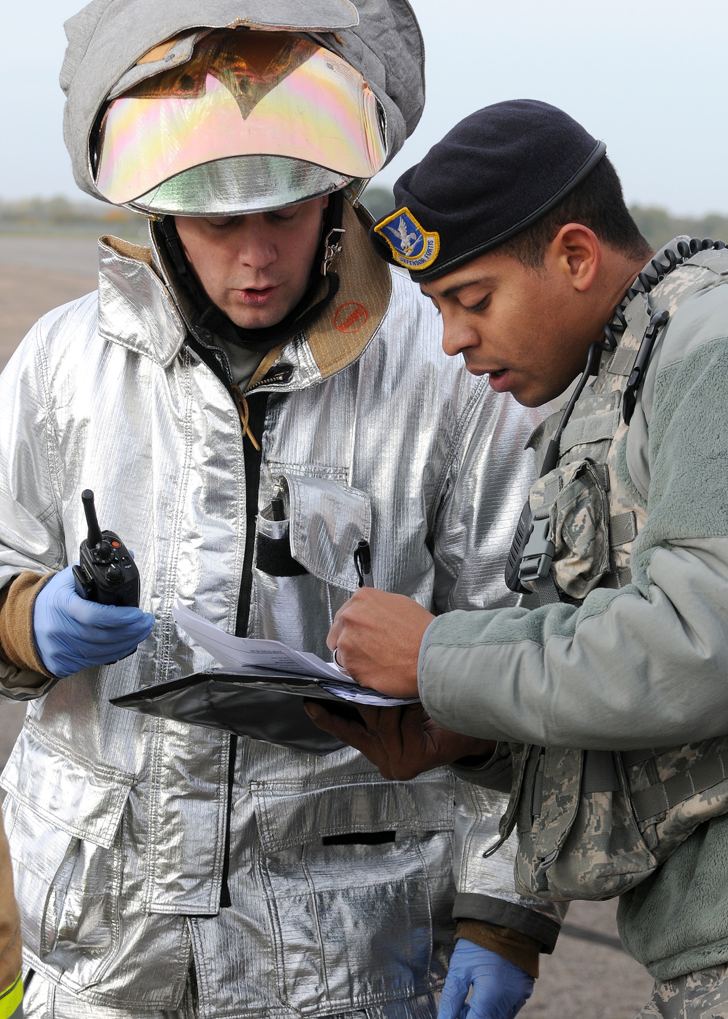 RAF MILDENHALL, England - Staff Sgt. Eduardo Canales, 100th Security Forces Squadron base defence operations controller (right), verifies the credentials of Phillip Semper, 100th Civil Engineer Squadron Defence Fire Service firefighter here, Nov. 2, 2010.  This MARE was used to prepare RAF Mildenhall firefighters for real-world aircraft mishaps.  (U.S. Air Force photos/Senior Airman Tabitha M. Lee) 