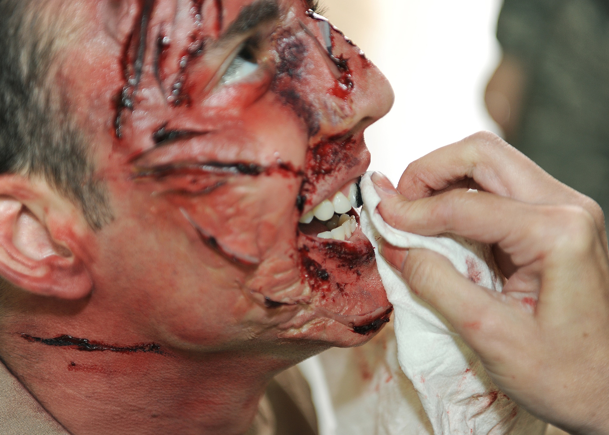 RAF MILDENHALL, England - Airman 1st Class Johnathon Bailey, 100th Logistics Readiness Squadron system administrator, gets his teeth blacked out here, Nov. 2, 2010, before the Major Accident Response Exercise.  A MARE is preformed to help prepare emergency response personnel for real world emergencies.  (U.S. Air Force photo/Senior Airman Tabitha M. Lee)  