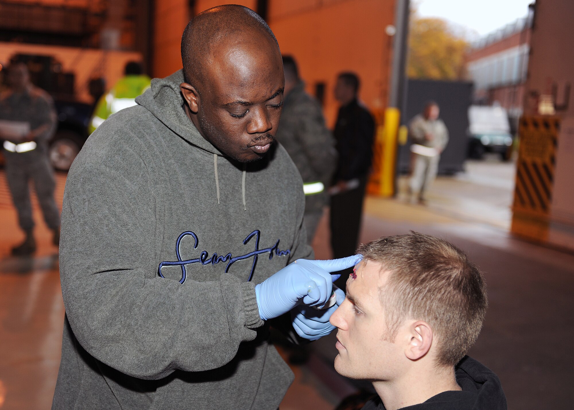 RAF MILDENHALL, England - Tech. Sgt. Micah Meyers, 48th Dental Squadron preventive dental NCO in, applies moulage to Staff Sgt. Andrew Lee, 100th Communications Squadron radio frequency transmission system supervisor, before the Major Accident Response Exercise here, Nov. 2, 2010.  This MARE was used to prepare RAF Mildenhall Firefighters for real world aircraft mishaps.  (U.S. Air Force photo/Senior Airman Tabitha M. Lee)  