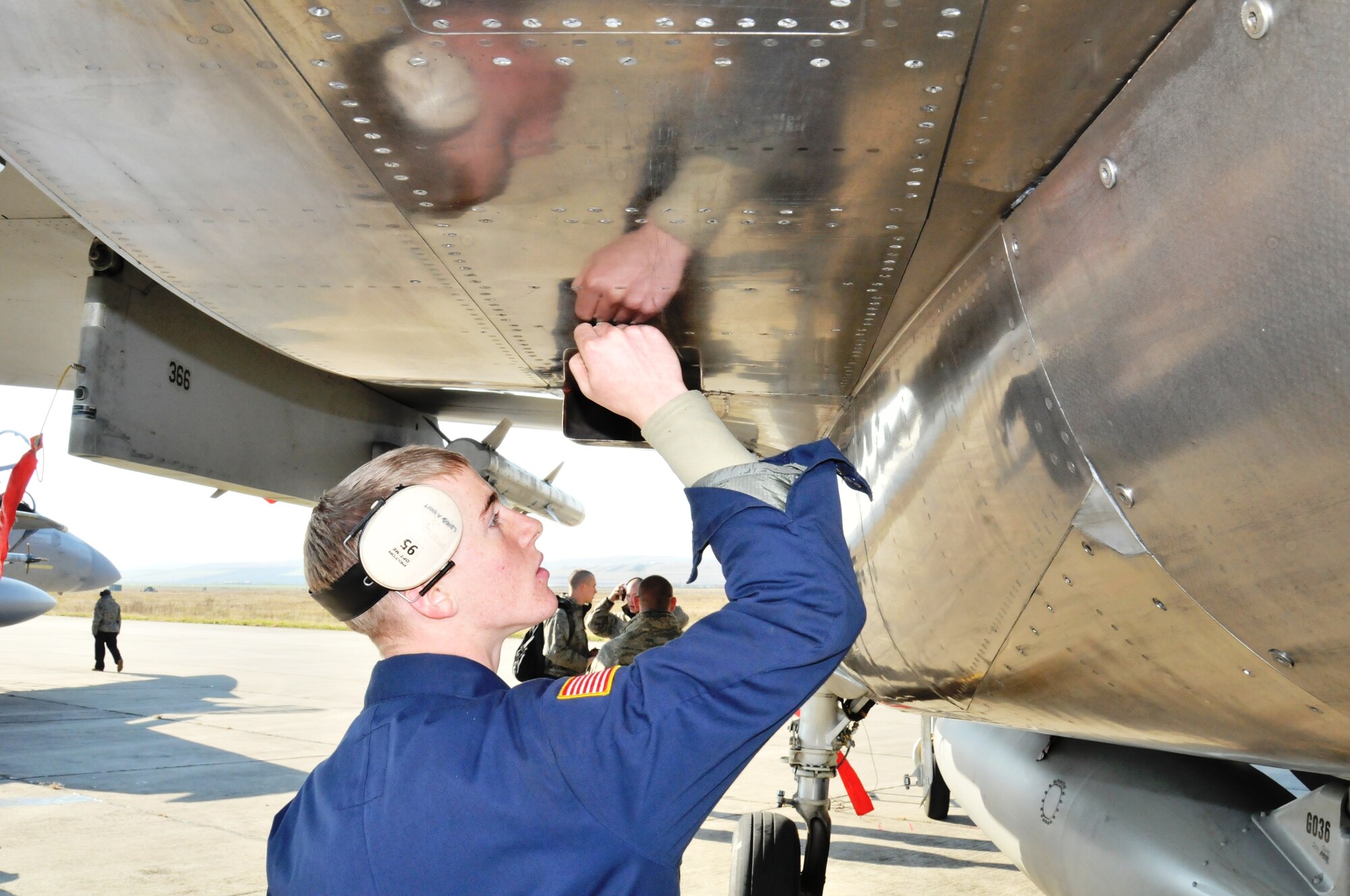 CAMPIA TURZII AIR BASE, Romania -- Airman 1st Class Zane Wilms, 748th Aircraft Maintenance Squadron assistant dedicated crew chief, checks the underside of an F-15C Eagle on the flightline here Oct. 28. The aircraft had just returned from a mission for Operation Golden Lance, a NATO partnership-building exercise. (U.S. Air Force photo/Senior Airman David Dobrydney)