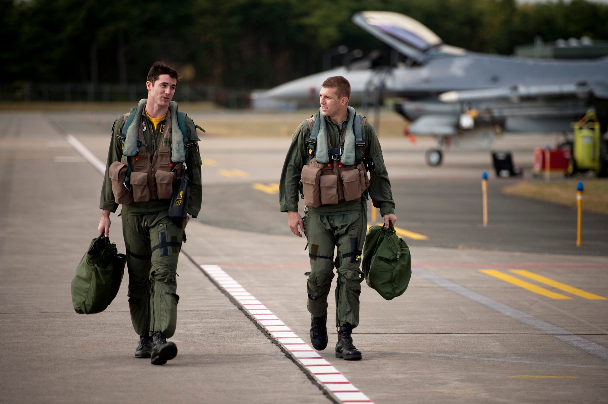 U.S. Air Force Capt. Chris Nations, 14th Fighter Squadron standardization and evaluations officer, and Staff Sgt. Bernard Mutz, 35th Civil Engineer Squadron readiness and emergency manager, return to the 14 FS building after an incentive flight in an F-16 Fighting Falcon at Misawa Air Base, Japan, Oct. 22, 2010. Sergeant Mutz said flying in an F-16 was an opportunity he never imagined he'd get, but having the incentive program pushes him to pursue excellence. The 35th Fighter Wing gives incentive flights to outstanding Airmen each year to reward their exceptional work and dedication. (U.S. Air Force photo by Staff Sgt. Samuel Morse/Released)
