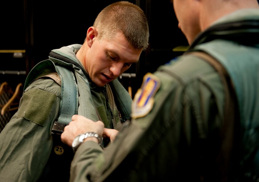 U.S. Air Force Capt. Chris Nations, 14th Fighter Squadron standardization and evaluations officer, assists Staff Sgt. Bernard Mutz, 35th Civil Engineer Squadron readiness and emergency manager, with his flight survival gear in the 14th FS locker room, Misawa Air Base, Japan, Oct. 22, 2010. Sergeant Mutz won the Sijan Award and 35th Mission Support Group Airman of the Year for 2009, earning himself an incentive flight for his accomplishments. (U.S. Air Force photo by Staff Sgt. Samuel Morse/Released)