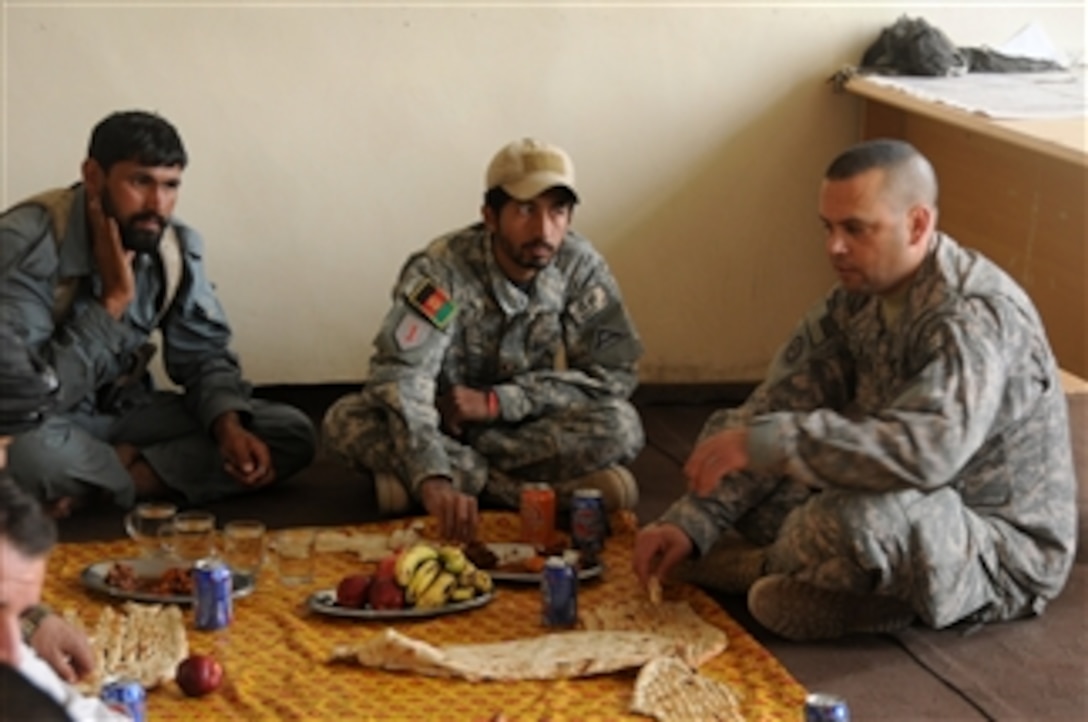 U.S. Army Lt. Col. Eliud Diaz (right), with Charlie Company, 1st Battalion, 4th Infantry Regiment, has lunch with an Afghan National Police commander (left) and other members of the Sha Joy community at the Sha Joy District Center off Highway 1 in Zabul province, Afghanistan, on Oct. 29, 2010.  