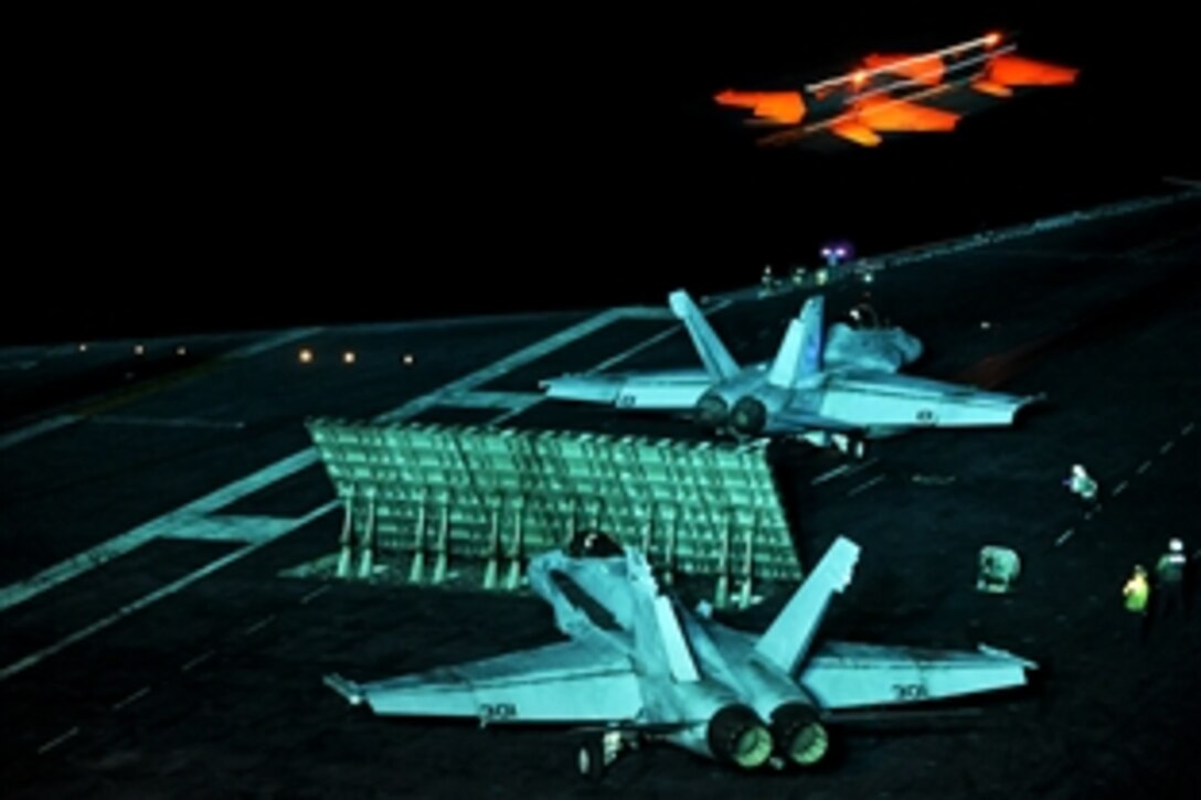 An F/A-18E Super Hornet  launches from the aircraft carrier USS Abraham Lincoln during night flight operations in the Gulf of Oman, Nov. 1, 2010. The aircraft is assigned to Strike Fighter Squadron 137, which supports maritime security and theater security cooperation efforts.