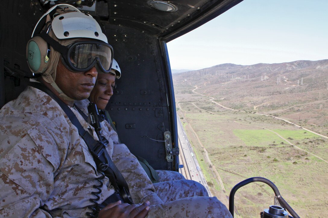 (Closest to furthest) Sgt. Maj. Larona E. Armstrong, Marine Aircraft Group 39 sergeant major and Sgt. Maj. Ramona D. Cook, Marine Corps Base Camp Pendleton sergeant major, look over the land of Camp Pendleton from a UH-1Y helicopter, Nov. 2. Also on board was Col. Nicholas F. Marano, commanding officer, MCB Camp Pendleton; Col. Thomas D. Weidley, commanding officer, MAG-39 and Col. James K. Lavine, operations and training officer, assistant chief of staff, who took the tour to view all of the new facilities on base.