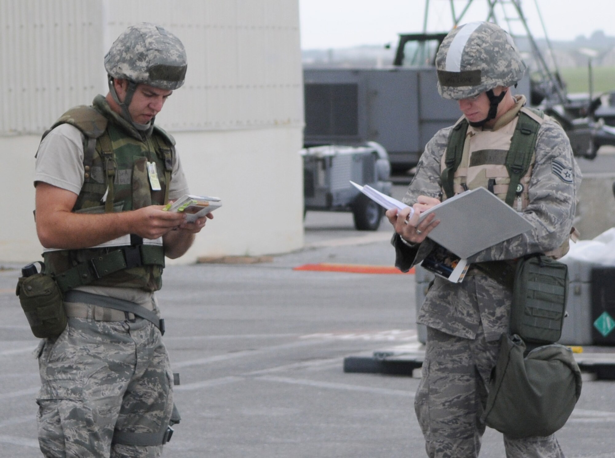 KADENA AIR BASE, Japan -- Senior Airman Charles Plott (left), 353rd Special Operations Maintenance Squadron, explains safety precautions and characteristics of simulated unexploded munitions to Staff Sgt. Daniel Van Stone, a 353rd Special Operations Support Squadron emergency management specialist, during a training scenario as part of Beverley High 11-1, a local readiness exercise. (U.S. Air Force photo by Tech. Sgt. Aaron Cram)