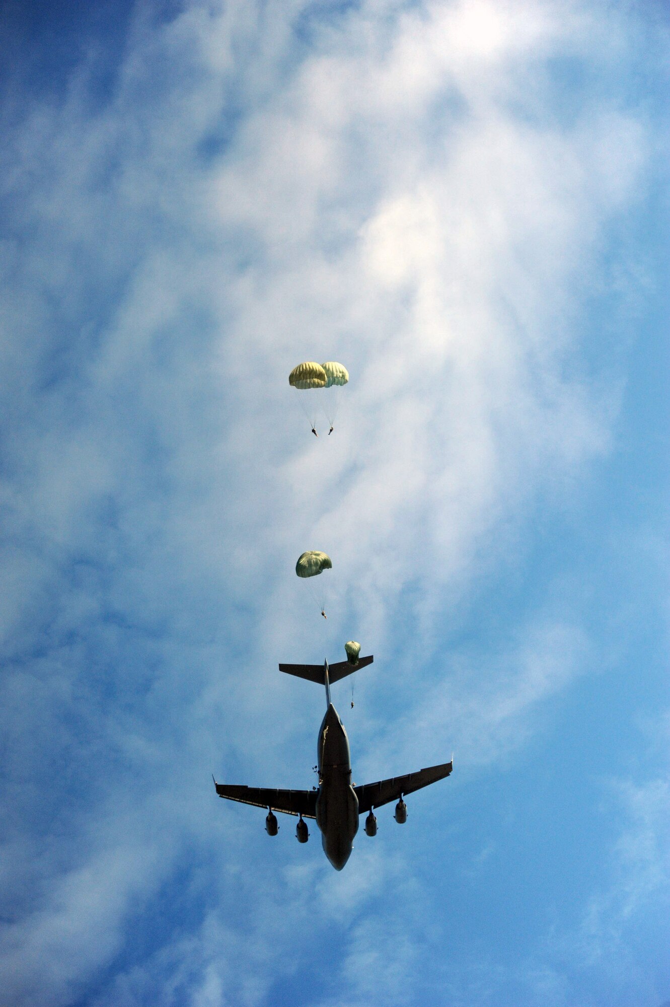 Paratroopers from the 507th Airborne School fall from the sky over Fort Benning, Ga., Oct. 14, 2010, after jumping out of a C-17 Globemaster from the 535th Airlift Squadron at Joint Base Pearl Harbor-Hickam, Hawaii. A C-17 aircrew from the 15th Wing flew from Hawaii to Fort Benning to support the student jump requirements of the 507th AS. (U.S. Air Force photo/Staff Sgt. Nathan Allen) 
