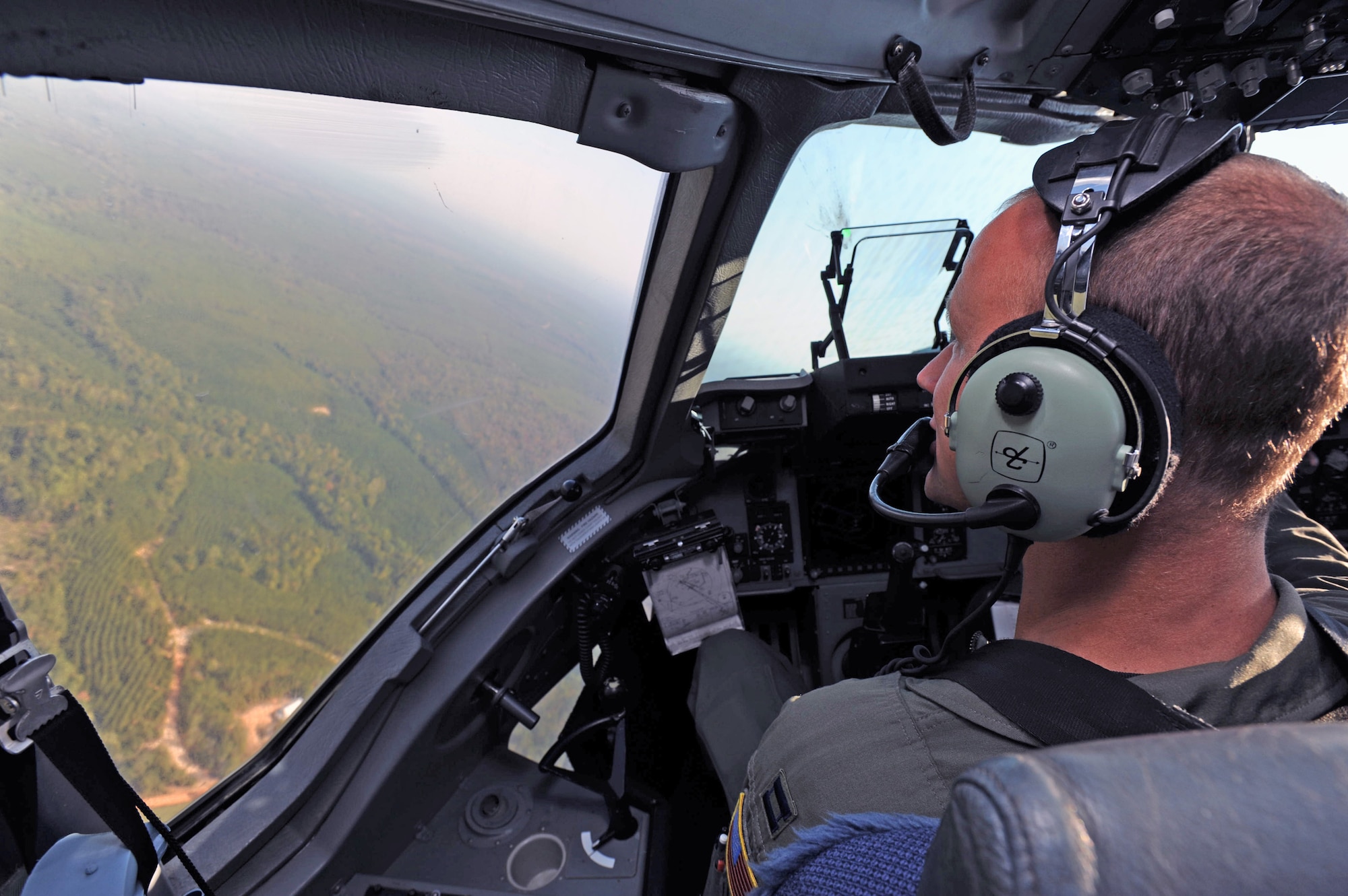 Capt. Mark Fischer surveys the landscape during a turn Oct. 11, 2010, at Fort Benning, Ga. A C-17 Globemaster III aircrew from the 15th Wing flew from Hawaii to Fort Benning to support the student jump requirements of the 507th Airborne School. Captain Fischer is a 535th Airlift Squadron pilot from Joint Base Pearl Harbor-Hickam.  (U.S. Air Force photo/Staff Sgt. Nathan Allen) 
