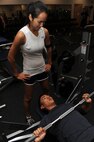 MINOT AIR FORCE BASE, N.D. -- Airman Ian Carrion, 5th Operations Support Squadron air crew flight equipment, warms up as Airman 1st Class Monica Diaz De Lope-Diaz, 5th OSS air crew flight equipment, spots him before starting his weight lifting routine at the McAdoo Sports and Fitness Center here Nov. 3. It is important to ensure an ample amount of strength training is incorporated into time spent at the gym. (U.S. Air Force photo by Airman 1st Class Aaron-Forrest Wainwright)