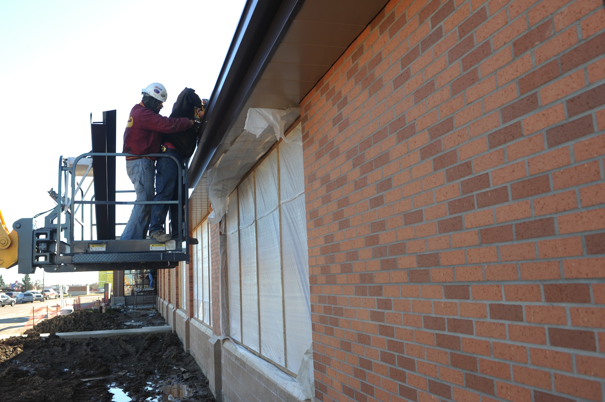 MINOT AIR FORCE BASE, N.D. -- Contractors Dustin Betzman and Lance Truax, install roof panels and gutters to the breezeway being built between the Commissary and Exchange here Nov. 3. The breezeway will help protect customers from harsh weather during the winter months as they transit from one building to the other. Construction on the breezeway is projected to be finished by the end of November. (U.S. Air Force photo by Airman 1st Class Aaron-Forrest Wainwright)