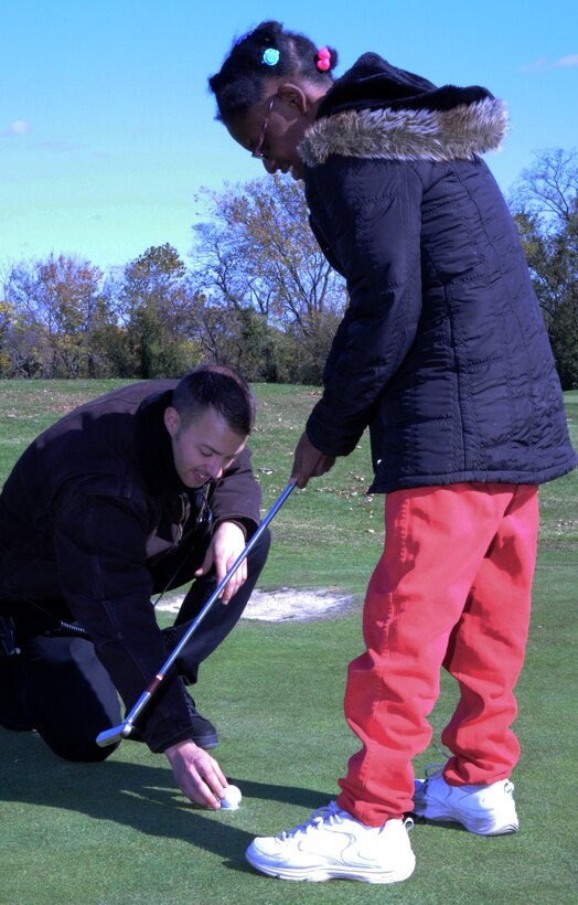 Senior Airman Michael Watson, 89th Aerial Port Squadron air transport specialist, assists an athlete during the golf competition at the Fall Classic Special Olympics held at Langston Golf Course in Washington, D.C., Nov. 1. Senior Airman Watson was one of 12 Andrews Airmen who volunteered at the event. (U.S. Air Force photo/ Airman 1st Class Bahja J. Jones)