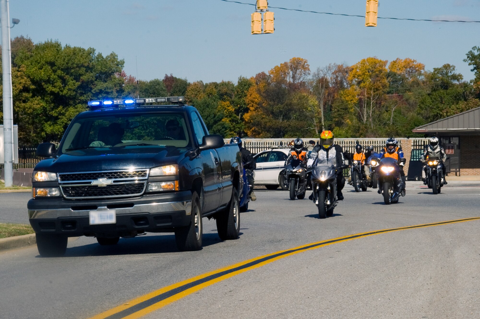 An 11th Wing Security Forces Squadron police truck leads a solemn convoy of motorcycle riders down East Perimeter Road and around the Andrews Air Force Base during their first Fallen Airmen Ride to pay tribute to Airmen who have had fatal accidents over the past year.  (U.S. Air Force photo/Bobby Jones)
